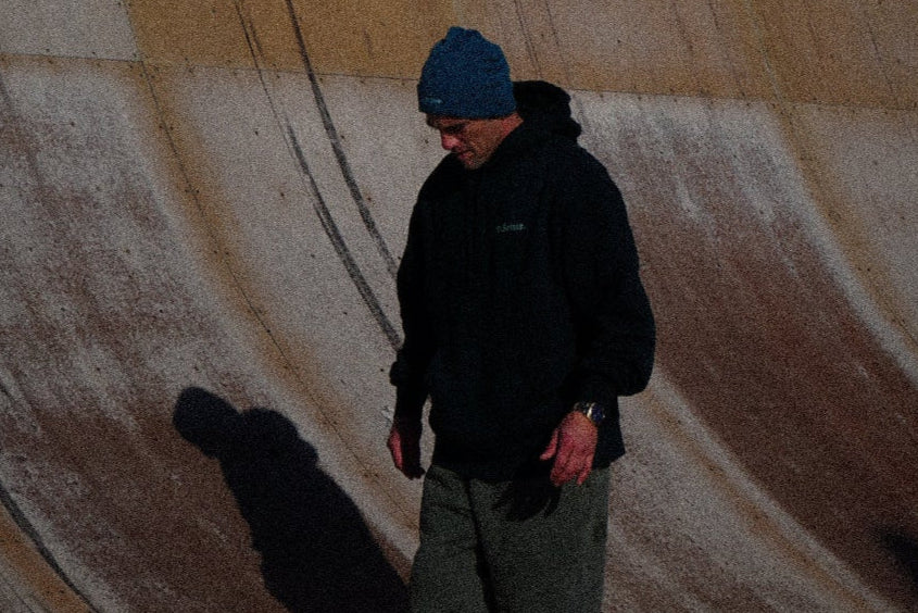 Be better founder Trent, at bottom of huge vert ramp wearing heavy Mens hood and Relax tracks casting a shadow on a wet surface