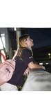 Person with a pink Be Better Duffel Bag leaning against a railing at night. wearing a Womens Heavy Tee in Plum Purple its a 280 gsm tee nice and heavy